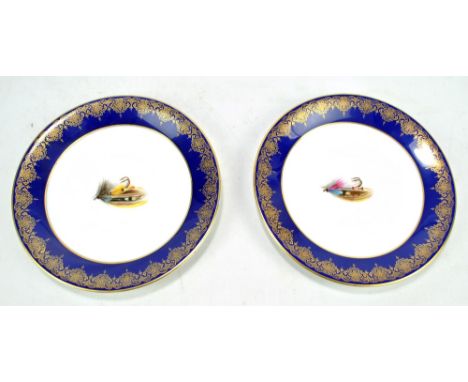 A pair of Royal Worcester cabinet plates, each painted with a fly fishing fly and with gilt heightened borders, marked in puc