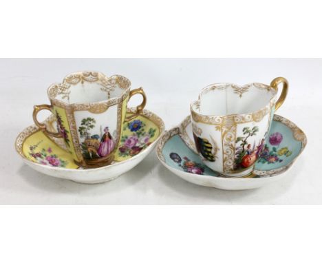 Two late 19th century Dresden porcelain lobed cups and saucers with gilt and overpainted figural and floral transfer decorati