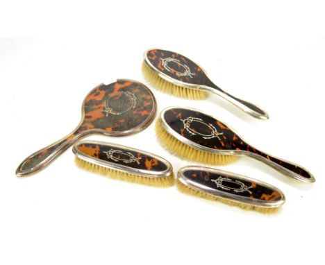 WILMOT MANUFACTURING CO; a George V hallmarked silver and tortoiseshell dressing table set, comprising two hair brushes, two 