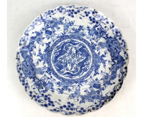 An early 20th century Japanese porcelain shaped circular charger transfer decorated with dragons amongst clouds chasing The P