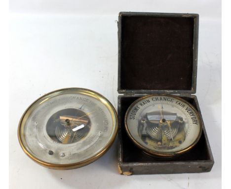 A circular brass cased aneroid barometer with silvered dial set with two thermometers, diameter 21cm, and a cased aneroid bar