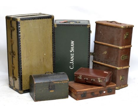 A group of six vintage trunks and suitcases.