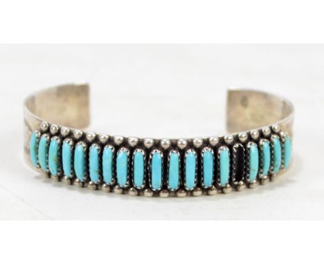 An FM Begay Navago sterling silver and turquoise bangle with beaded detail and stylised bright cut decoration, maker's mark s