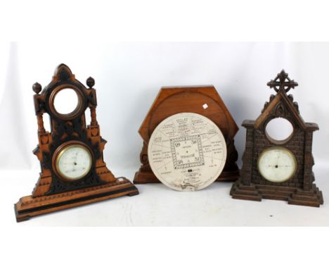 Two late Victorian Gothic cases, each set with a barometer beneath an aperture for a clock, also a hexagonal framed Stormogui