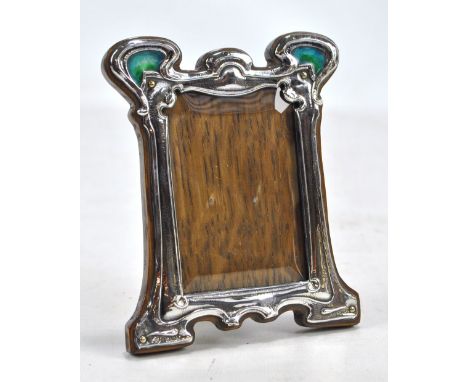 WILLIAM HUTTON &amp; SONS LTD; an Edward VII hallmarked silver fronted Arts and Crafts shaped rectangular photo frame with bl