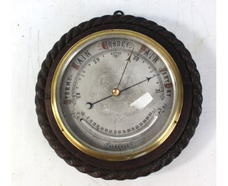 An early 20th century oak circular barometer with silvered dial and thermometer, diameter 29cm.