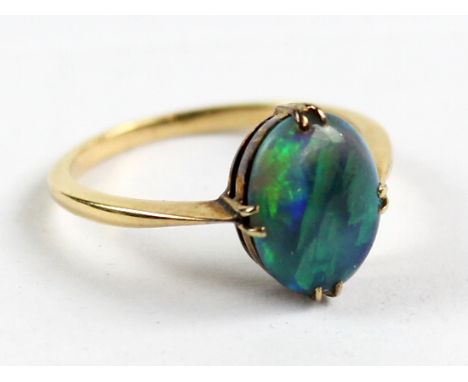 A yellow metal ring set with oval opal in a claw setting, size N, approx 2.7g, in John Payne of Blackpool box.