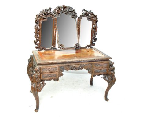 An elaborate Chinese carved early 20th century dressing table with triptych mirror above Greek key decorated rectangular top,