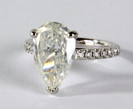 A platinum and diamond ring, the principal pear shaped stone weighing approx 3.01cts (colour J, clarity SI2), with further di