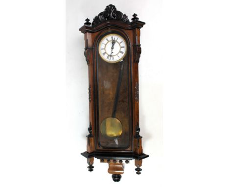 A circa 1900 walnut and ebonised Vienna style single weight wall clock, the two-piece white enamel dial set with Roman numera