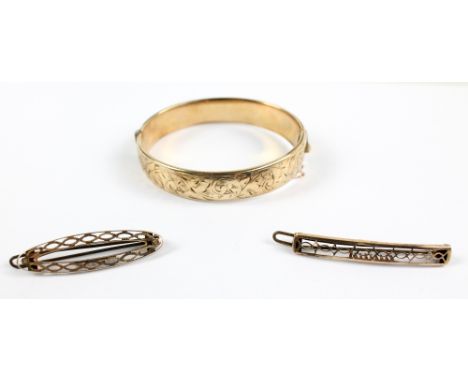 A 9ct yellow gold and metal core foliate scroll engraved snap bangle with safety chain, and two 9ct yellow gold open frame ha