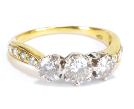 An Italian 18ct yellow gold three stone diamond ring with graduated stones in white metal claw setting, combined approx 1.13c