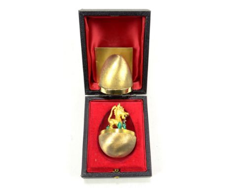 STUART DEVLIN; a limited edition Elizabeth II hallmarked silver gilt egg enclosing a figure of donkey and a mouse seated on a