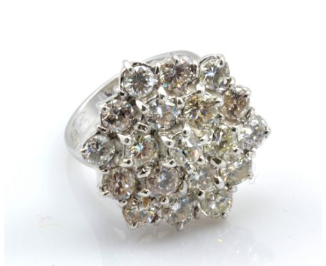 An 18ct white gold and diamond floral cluster ring set with nineteen round brilliant cut stones in a stepped setting, each di