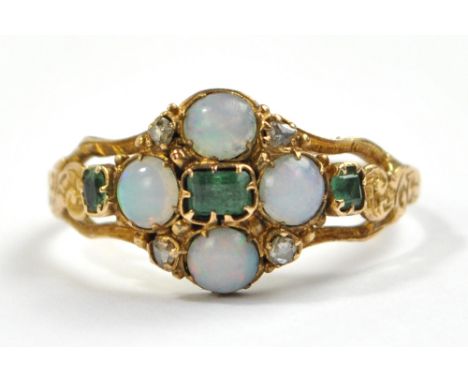 An early 20th century yellow metal dress ring set with four opal cabochons alternating with four diamond chips and three gree