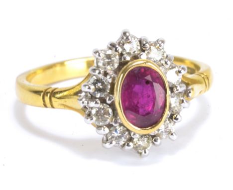 An 18ct yellow gold ruby and diamond cluster ring set with oval cut stone in bezel setting, approx 0.85ct, within border of t