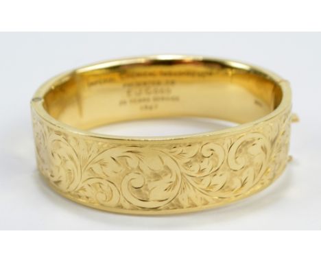 A 9ct yellow gold hollow snap bangle engraved with foliate scrolls, with Imperial Chemical Industries Ltd presentation inscri