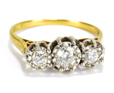 An 18ct yellow gold illusion set three stone diamond ring, the central stone weighing approximately 0.2ct, size N1/2, 4g.