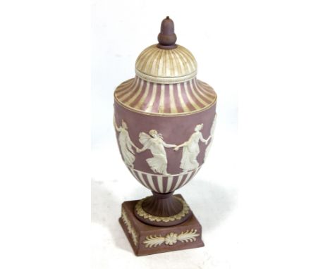 A Wedgwood lilac jasperware lidded urn on square plinth with 'Dancing Hours' figural frieze, impressed marks to base and code