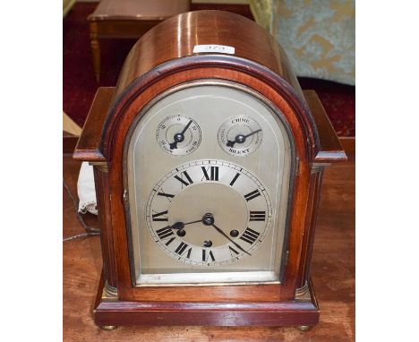 An Edwardian mahogany chiming mantle clock, arched dial with numeral chaptering, two dials for fast/slow and chime/silent sel