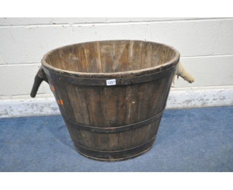 A VINTAGE OAK AND COOPERED OVAL GRAPE BARREL, of a tapered form, with twin handles, width 87cm x depth 50cm x height 53cm (co