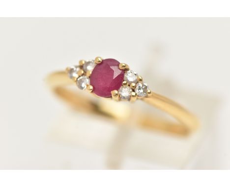 AN 18CT GOLD RUBY AND DIAMOND RING, designed as a central oval cut ruby flanked by a triple cluster of brilliant cut diamonds