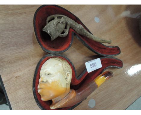A Meersham pipe modelled as an African man and a pipe modelled as a claw