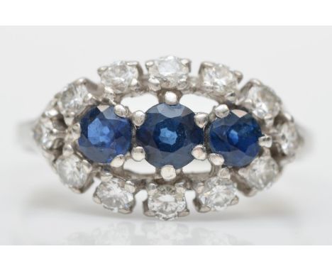 An unmarked 18ct white gold three sapphire and brilliant cut diamond cluster ring, diamond weight approximately 0.60cts, R, 3