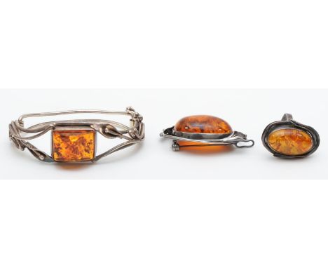A silver set amber bangle, a silver set amber brooch and ring, 54g. 
