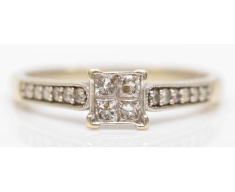 A 9ct white gold and four Princess cut diamond ring, brilliants to the shoulders, stated weight 0.40cts, R, 2.6gm 