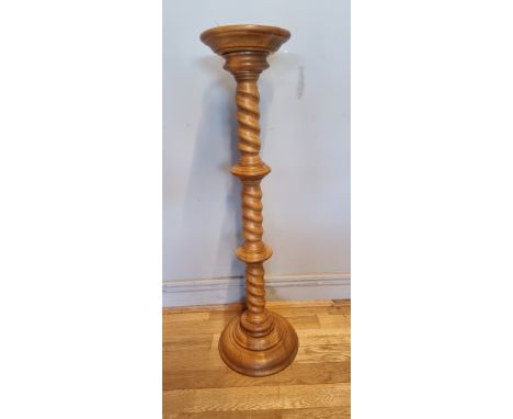 A solid light oak jardinière/plant stand, having turned column on a round stepped base.H99cm. 