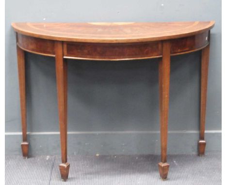 A Georgian style reproduction mahogany and banded demi lune shape console or side table, the fan patera top on square taperin