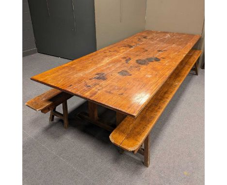 A mid 20th century teak or hardwood trestle table of massive proportions, in the Heal's style, complete with long benches. (3