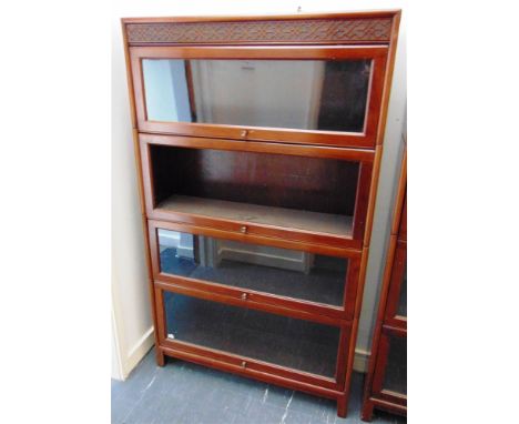 A FOUR SECTION MAHOGANY GLOBE WERNICKE STYLE BOOKCASE  with blind fret carved frieze, 87cm wide 25cm deep 146cm high