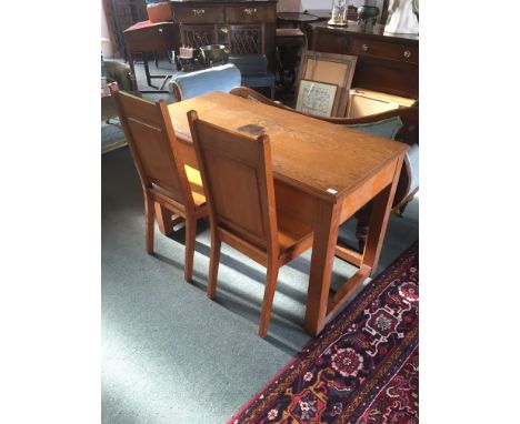 A LIGHT OAK SIDE TABLE  122cm wide 60cm deep 77cm high, together with a matching pair of chairs, each with crucifix decoratio