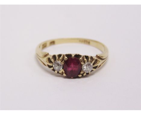 A DIAMOND AND RUBY THREE STONE RING stamped '18', circa 1910, the oval cut approximately 0.2 carats estimated, finger size P,