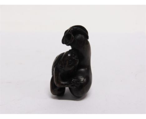 A CARVED HARDWOOD NETSUKE  modelled as a monkey with a gourd, signed to an inlaid circular mother-of-pearl seal, 5cm high