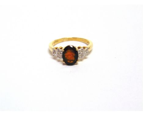 A 9 CARAT GOLD OPAL RING the oval cut stone with a trio of cubic zirconias to each shoulder, finger size O, 2.6g gross