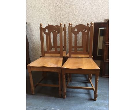 A SET OF FOUR LIGHT OAK CHAPEL TYPE HALL CHAIRS  with pierced trefoil decoration
