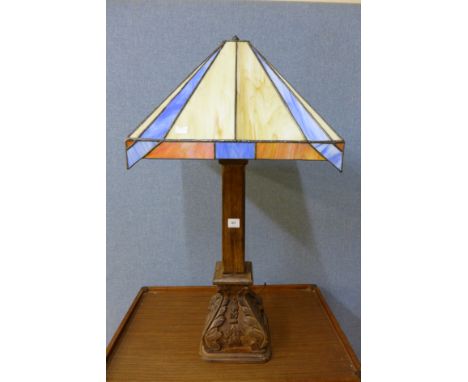 A Tiffany style lamp shade on carved wood lamp stand