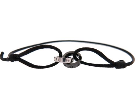 A ceramic and white gold 'LOVE' bracelet by Cartier, the interconnecting white gold and black ceramic loops on black silk bra