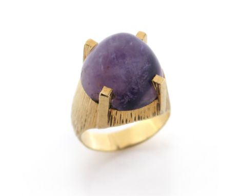 An amethyst-set gold ring, the domed cabochon amends is set in textured yellow gold, size O 1/2, 9.4g
Condition report:&nbsp;