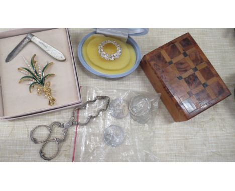 A pair of scissor action sugar tongs, together with a mother or pearl fruit knife, two brooches, coins etc