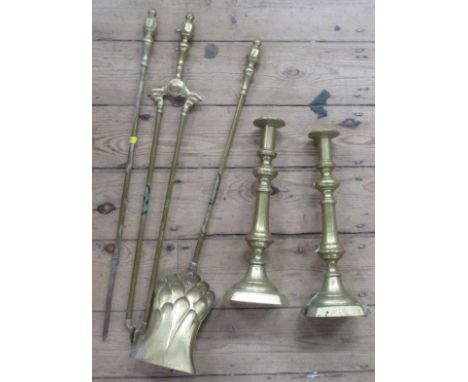 A pair of brass candlesticks, height 14ins, together with a three pieces brass fire tool set
