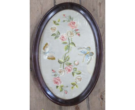 A 19th century oval tapestry on silk, of flowers, in a mahogany frame, 20ins x 13.5ins to include frame