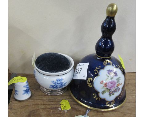 A porcelain bell, together with a porcelain pin cushion and a thimble