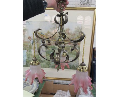 An Art Nouveau brass hanging light fitting, with three cranberry and frosted glass frilly shades