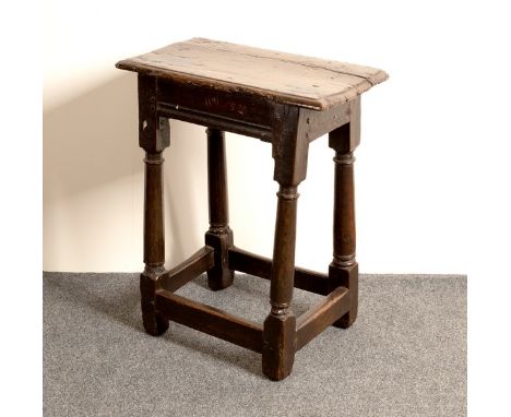 A 17th Century oak joint stool, the rectangular top with moulded border on round tapered legs and square stretchers, initiall