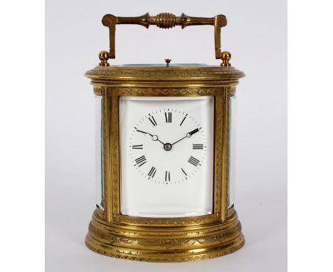 A gilt brass carriage clock in an oval engraved case, with eight-day hour repeat movement striking on a gong, 16cm high CONDI