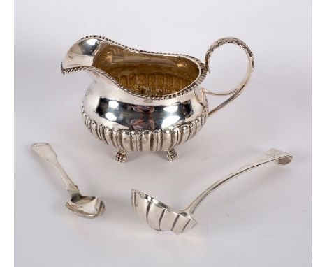 An Irish silver jug, James le Bas, Dublin 1826, with gadrooned rim and half-ribbed body, crested, a hook-end silver sauce lad